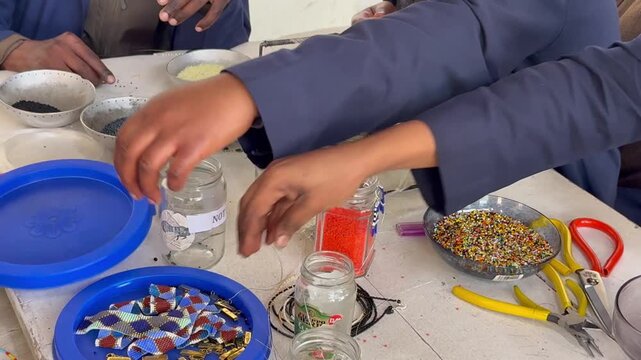 African workers stringing beads to make bracelets