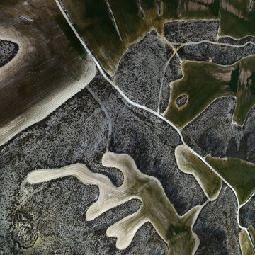 Aerial view of the contrasting textures and tones of cultivated fields create an abstract mosaic across the landscape., Villamayor de Gallego, Zaragoza, Spain.