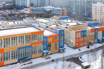 Modern colorful school complex in winter cityscape © svetlana