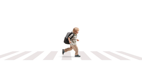 Naklejka premium Full length profile shot of a young boy with a backpack running over a pedestrian crossing