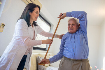 Caregiver assisting elderly man with rehabilitation exercises at home