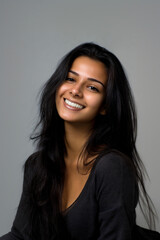 Obraz premium smiling young woman portrait with soft lighting and copy space, minimal headshot of young woman looking at camera on gray background, clean beauty portrait of smiling female face with neutral backdrop