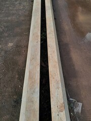 Long narrow concrete drainage canal on a dirt ground