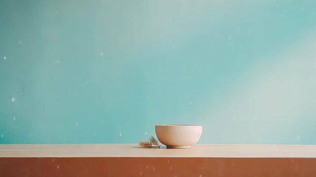 Empty ceramic bowl with dried botanical accents on light wood, set against a serene teal to blue gradient wall with soft shadows minimalist, warm, calm product display