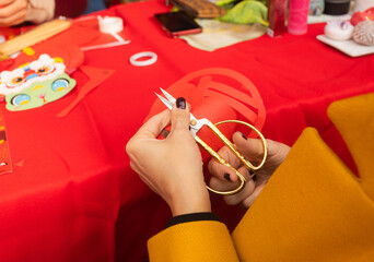 Chinese New Year papercutting workshop - create traditional festive symbols and Chinese characters from red paper. Cultural craft activity celebrating Lunar New Year traditions