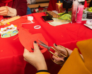 Chinese New Year papercutting workshop - create traditional festive symbols and Chinese characters from red paper. Cultural craft activity celebrating Lunar New Year traditions