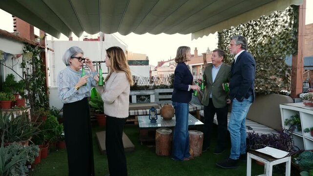 Business people talking and drinking beer during an after work party on an urban rooftop