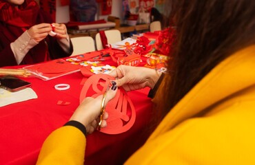 Chinese New Year papercutting workshop - create traditional festive symbols and Chinese characters from red paper. Cultural craft activity celebrating Lunar New Year traditions
