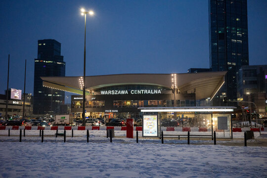 WARSAW, MASOVIAN, POLAND - JANUARY 24, 2026: The illuminated facade of the Warszawa Centralna railway station stands against a dark blue twilight sky during a snowy winter evening