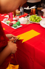 Chinese New Year candle workshop - create traditional festive symbols and Chinese characters from red paper. Cultural craft activity celebrating Lunar New Year traditions