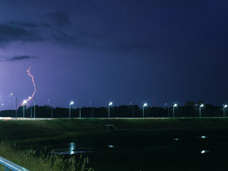 Stormy sky with lightning over the night highway