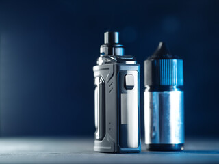 electronic cigarette with a replaceable cartridge or vaporizer and liquid for electronic cigarettes on a dark blue background. Copy space