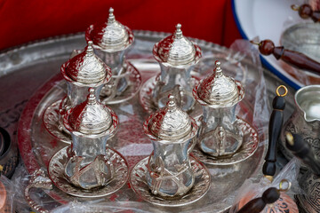 Fototapeta premium Metal coffee cezve with decorative oriental pattern on the shop window. Household items copper items for sale. Cupric coffeepots at the bazaar in Antalya Turkey. Turkish coffee pots. Metal coffee cezv