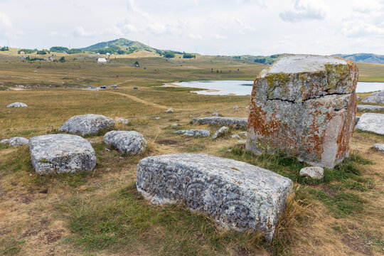 Weathered ancient tombstones dot a windswept grassland