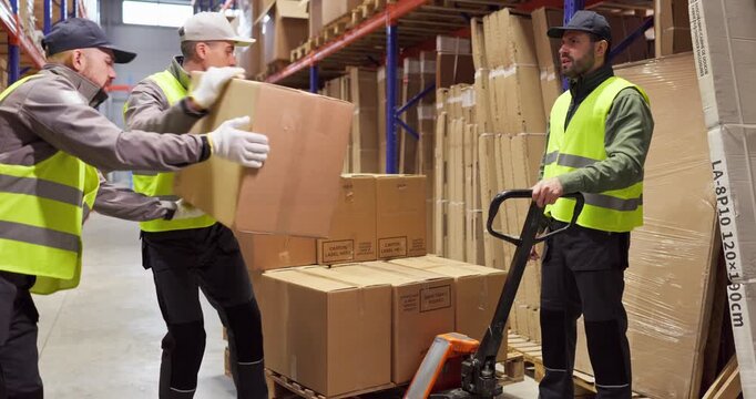 Workers warehouse loading boxes pallet trolley manual. Team in vests uses a pallet trolley near shelving for picking, supporting shipping and delivery. Clean and safe logistics concept.