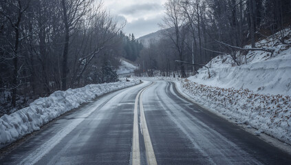 Fototapeta premium 新雪に覆われた山道のS字が冬の静けさに消えていく