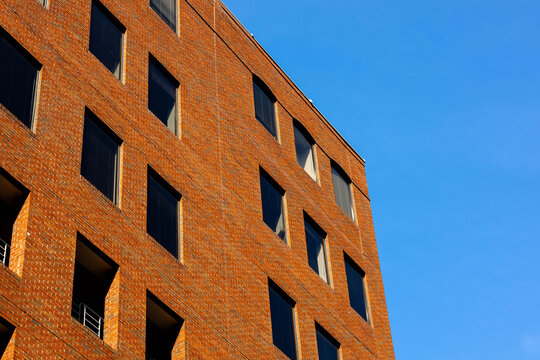 Modern Red Brick Office Building Exterior under Clear Blue Sky