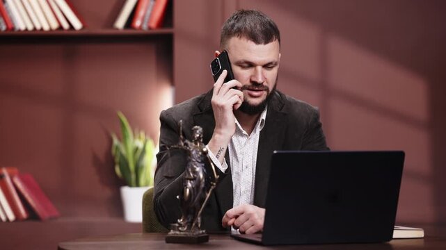 Law and justice concept with male attorney working on laptop at desk, Lady Justice statue symbolizing fairness and legal responsibility in modern office.