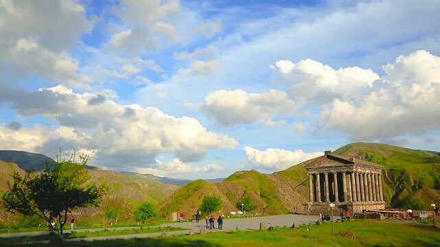Garni Temple Armenia Mountain Landscape. Wide view of ancient Garni Temple in Kotayk Province Armenia set in green hills under blue sky ideal for tourism culture and travel ads. Static wide shot on tr