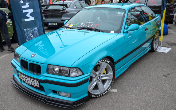 Custom turquoise BMW 3 Series E36, classic 1990s sports sedan features significant modifications, including lowered stance front splitter and aftermarket alloy wheels