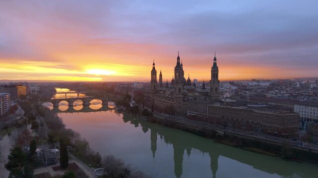 Aerial View Capturing Sunset Glow Illuminating Cathedral Domes And Tranquil River Reflections. Zaragoza. Spain 