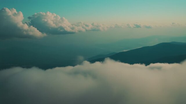 Vast calming sky creates abundant copy space above a peaceful distant mountain range and a layer of soft cumulus clouds, evoking tranquility and openness