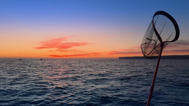 Fishing landing net at Costa Blanca sunset over Mediterranean sea