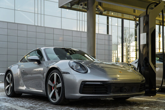 Silver Porsche 911 Carrera S VIII (992), 2021 sports car parked at the city street. Grey coupe car Porsche 911 Carrera S VIII 992 on parking lot. The modern exterior Porsche 911 4S Germany sport car.