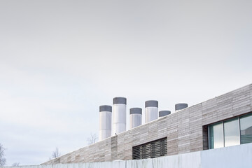 Obraz premium Flue chimney fixed to building exterior wall stainless steel from exhaust boiler plant room