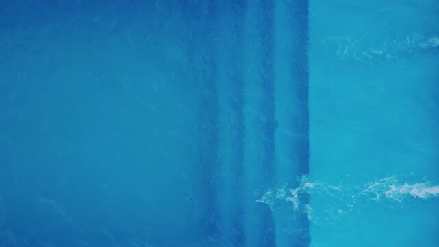 Aerial top-down view of a blue swimming pool with return jets circulating fresh water. Close-up. Concept of summer vacation, pool maintenance