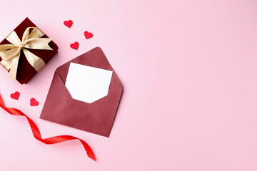 Saint Valentine's day. Beautiful gift, envelope with greeting card, decorative hearts and ribbon on...
