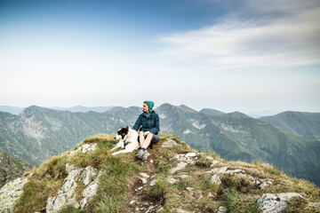 Obraz premium woman trekking with a dog in high mountains