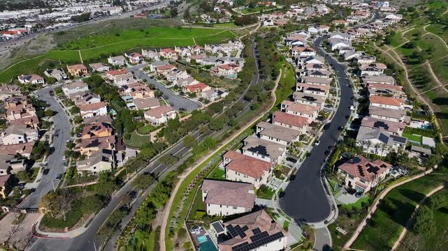 Aerial view over San Juan Capistrano, California, featuring the historic mission, library, sports courts, and an Amtrak train pulling into the downtown station. High quality 4k footage
