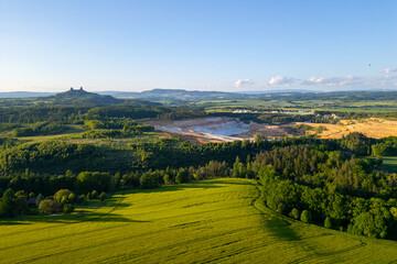 Obraz premium Trosky Castle set against a vast countryside during summer in Bohemian Paradise. Green fields and distant hills create a beautiful landscape in Czechia.