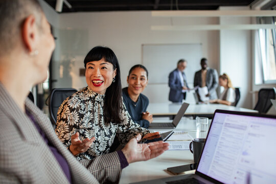 Diverse coworkers collaborating during team meeting in modern office