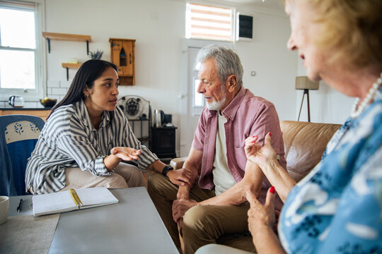 Caregiver discussing care plan with senior couple at home