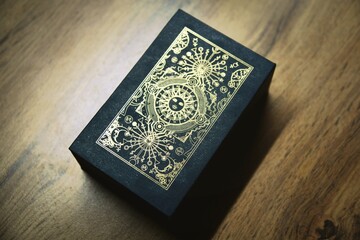 Fortune teller and whitcraft concept with tarot cards spread on red velvet surrounded by a magic crystal ball, gold bracelet, a book and a wooden box