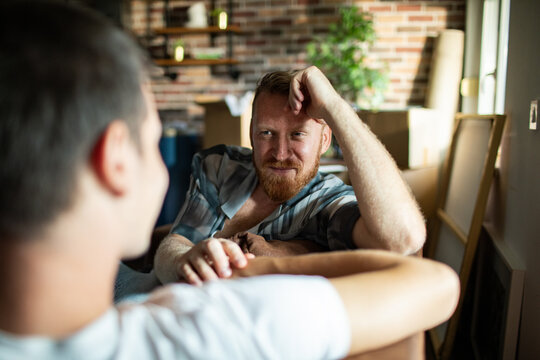 Two men relaxing and talking at home