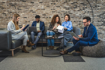 Diverse business team collaborating in modern office lounge area