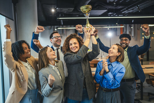 Diverse business team celebrating success winning golden trophy award
