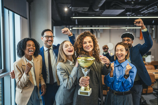 Diverse business team celebrating success winning golden trophy award