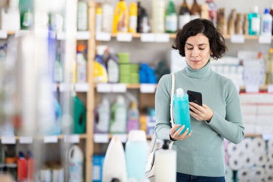 Adult woman buyer scanning qr code for shampoo or shower gel in household chemicals store