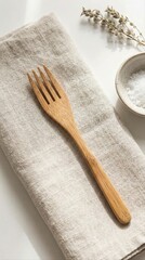 Fototapeta premium eco-friendly bamboo fork on linen napkin with sea salt bowl and dried herbs