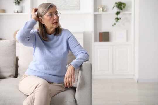 Amnesia. Senior woman trying to remember something at home, space for text