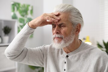 Obraz premium Amnesia. Senior man trying to remember something at home