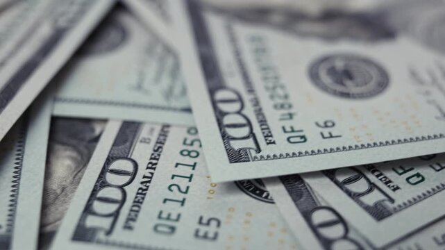 Close-up sequence of US dollar banknotes showcasing intricate details and designs, highlighting the texture and colors of the currency in a visually rich arrangement