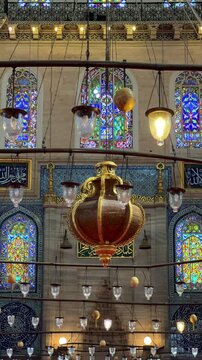 Istanbul, August 9, 2024: Inside the S&uuml;leymaniye Mosque. The prayer hall is decorated with blue tiles, stained glass windows, Quranic verses, and ornaments. The floor is covered with a large carpet.4К
