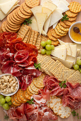 Charcuterie and cheese board with variety of meat and cheeses, crackers and nuts