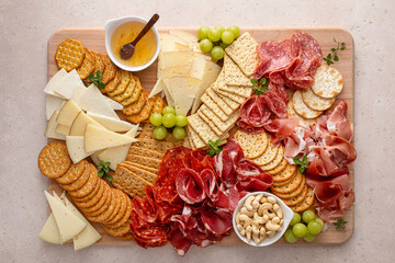 Charcuterie and cheese board with variety of meat and cheeses, crackers and nuts