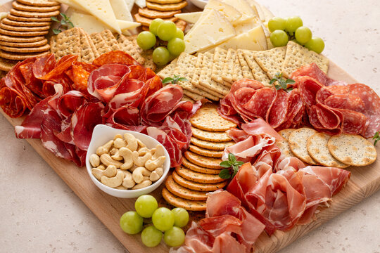 Charcuterie and cheese board with variety of meat and cheeses, crackers and nuts